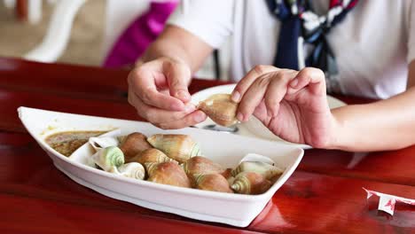 person savoring boiled wing shell seafood