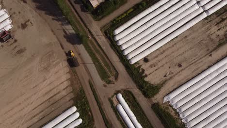 tractor taking harvest from farm silo bags