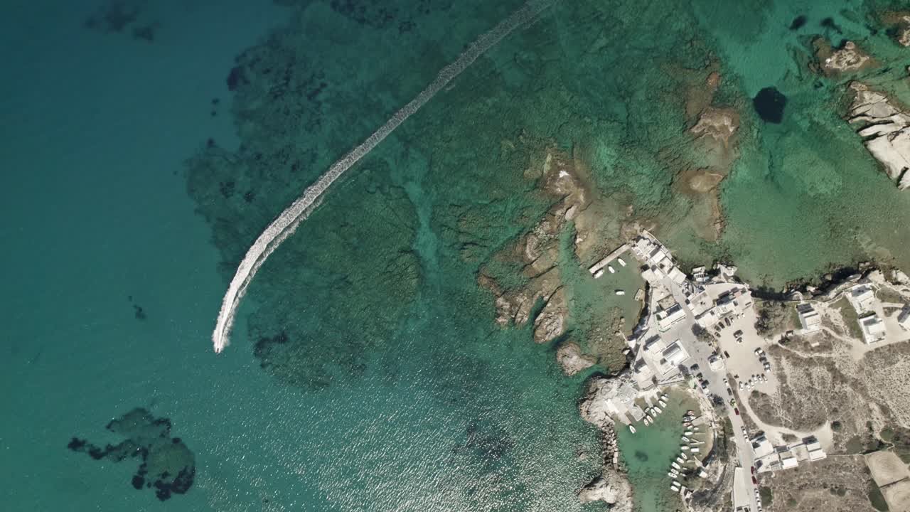 제트 스키가 지중해의 수정처럼 맑은 바다를 돌진할 때 그리스의 작은 마을을 선회하는 장면