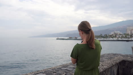 en una antigua plaza europea, una joven madre camina con su hijo bebé cerca del océano, ambos mirando las olas y compartiendo sonrisas conmovedoras