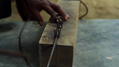 manual bending iron steel in construction site african black male carpenter hands close up