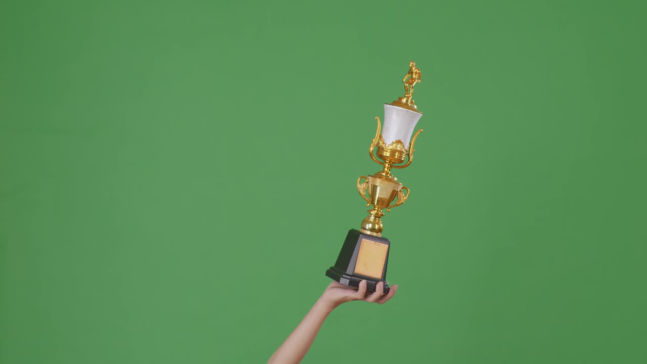 hombre sosteniendo un trofeo de oro campeón. fondo de pantalla verde