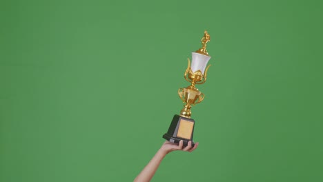man holding a champion golden trophy. green screen background