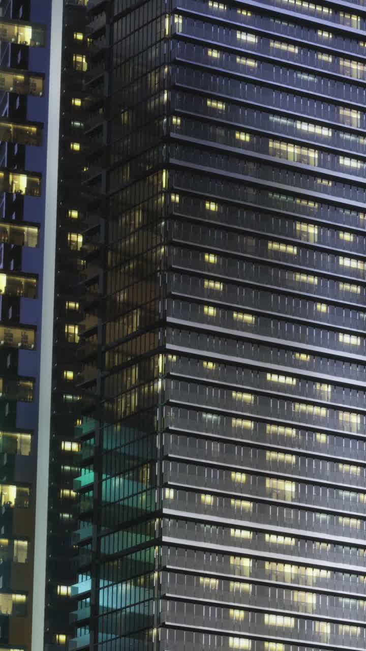 City buildings shine at night with lights glowing from windows