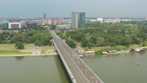 aerial shot of thousand of runners in a marathon crossing a bridge in belgrade