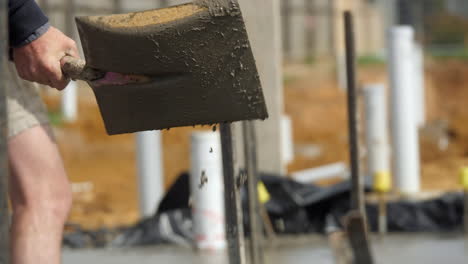 close up wet cement flicked off shovel onto newly laid house slab