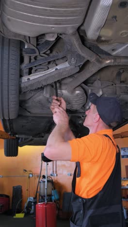 mechanic working under a car in a repair shop