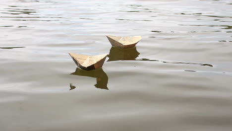 Kid Having Fun Outdoors. Boy playing with paper boats by a river on summer day