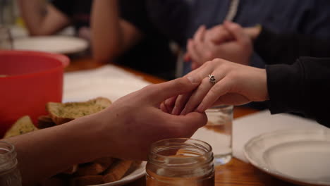 close up of hands in prayer at dinner table friends community fellowship