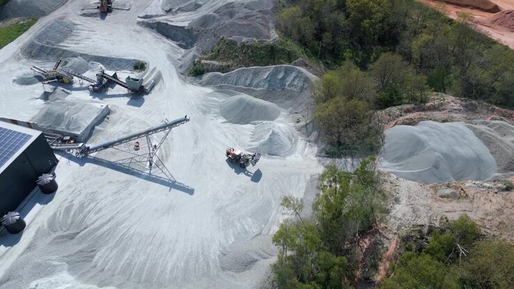 Piles of white foamed glass aggregate leading to sorting machinery, forward drone flight in the UK