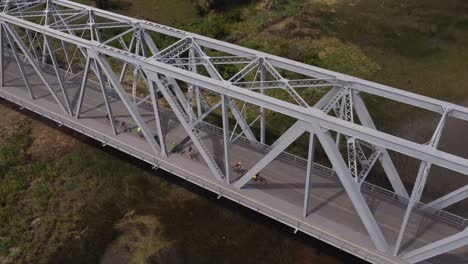 Luftaufnahme-Von-Radfahrern,-Die-In-Den-Frühen-Morgenstunden-Auf-Der-Brücke-Fahren