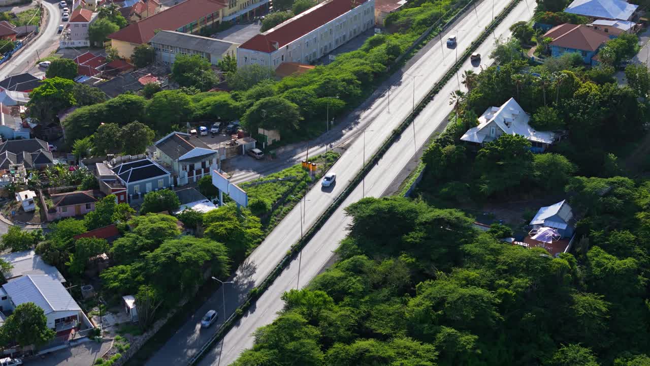 드론은 자동차가 운전하는 동안 정오에 빛이 을 때 반이는 밝은 아스팔트를 밀어 넣습니다.