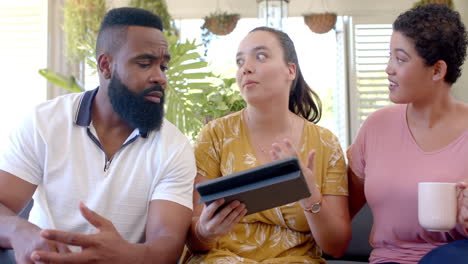 using tablet and discussing, diverse group of friends sitting together