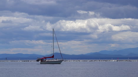 A-sailboat-leaves-harbor-with-sails-furled,-under-engine-power