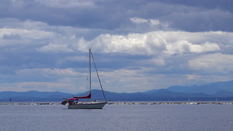 un velero sale del puerto con las velas dobladas, bajo la potencia del motor
