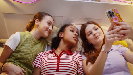 chicas adolescentes tomando una selfie en una cama