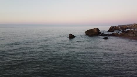 sobrevuelo sobre las ruinas de la fortificación de hormigón del puerto de guerra de karosta en la costa del mar báltico en liepaja en una hermosa puesta de sol, gran angular que establece disparos de drones moviéndose hacia atrás