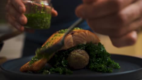 close up shot of chef marinates grilled salmon with healthy spinach in restaurant