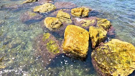 las olas del océano golpean las rocas en aguas claras