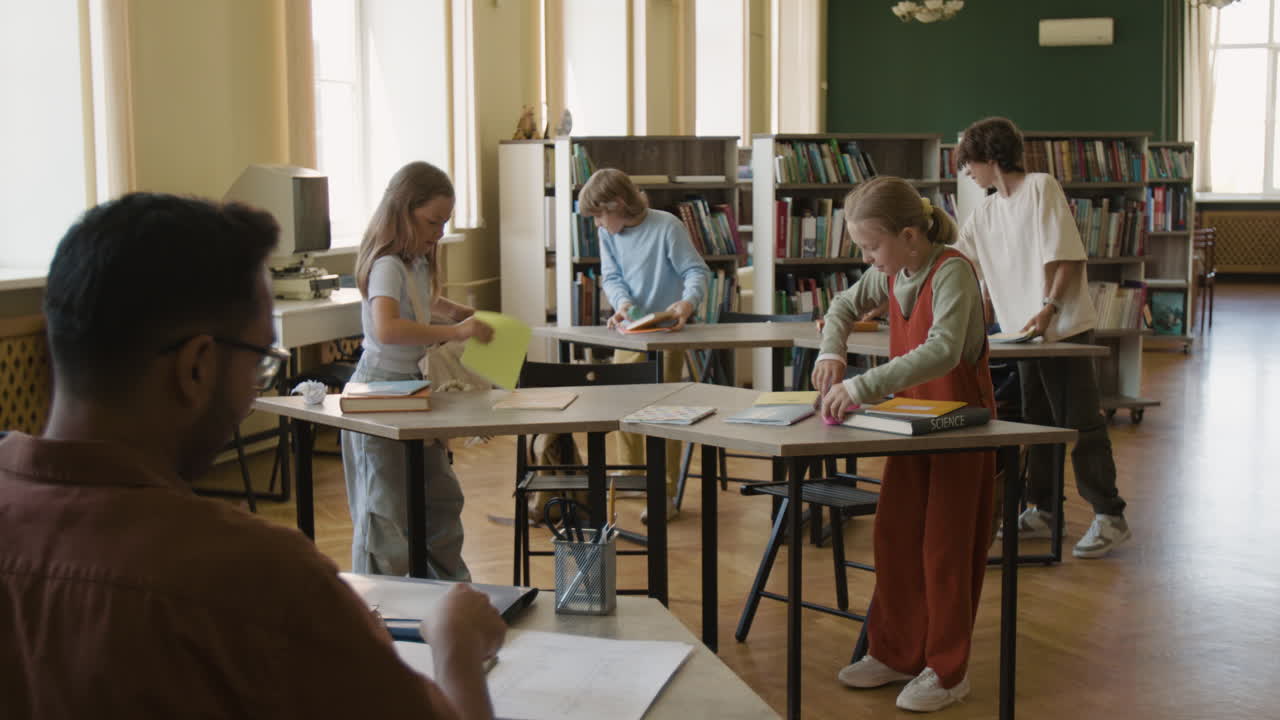 Students and teacher preparing for class in a school library