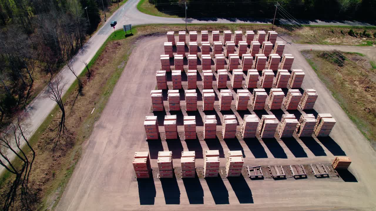 Aerial view of stacked lumber piles in industrial yard in Iron River, Michigan, USA
