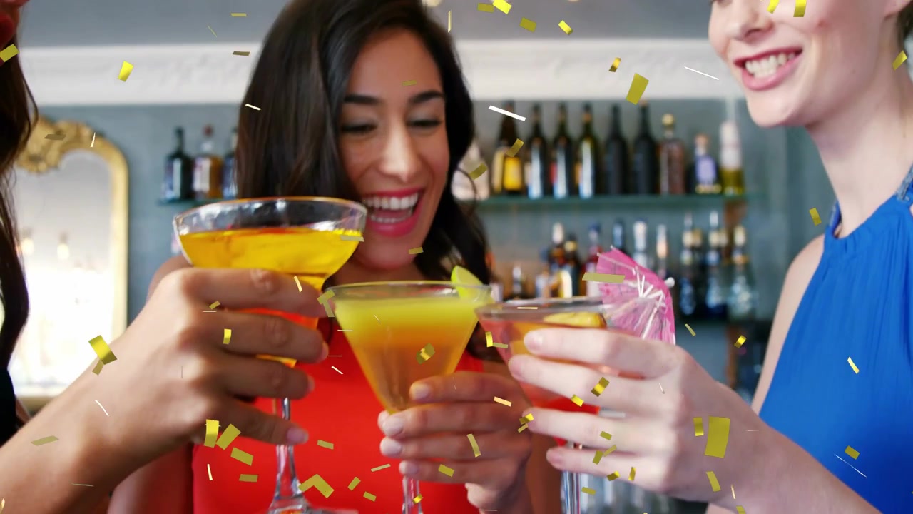Center woman leading friends raising drinks at bar, gold confetti initiating party toast