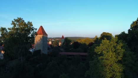 Links-Fliegt-Eine-Drohne-Im-Park-Rechts-Sieht-Man-Die-Alte-Historische-Stadt-Bäume-Davor-überdachte-Fußgängerbrücke