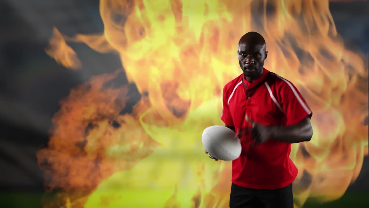 Professional rugby player holding a ball with flames in the background