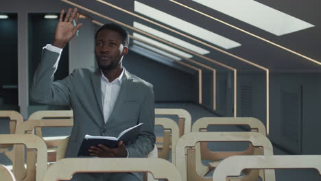 portrait of young african man asking question during lecture