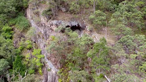 Antenne---Höhle-Inmitten-Von-Bäumen-Auf-Einem-Felsigen-Berghang