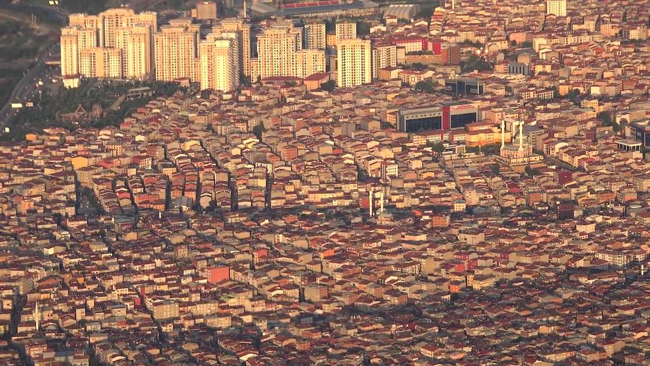Vista aérea de un barrio urbano densamente poblado al atardecer.
