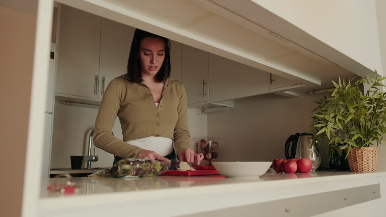 mujer cortando verduras en una cocina moderna