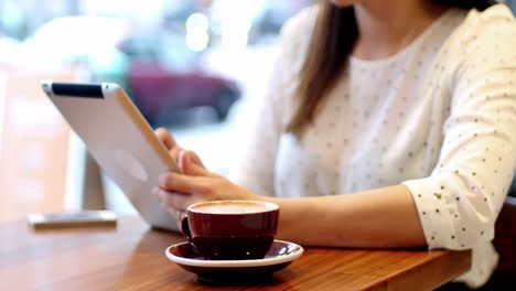 businesswoman using digital tablet in cafã©