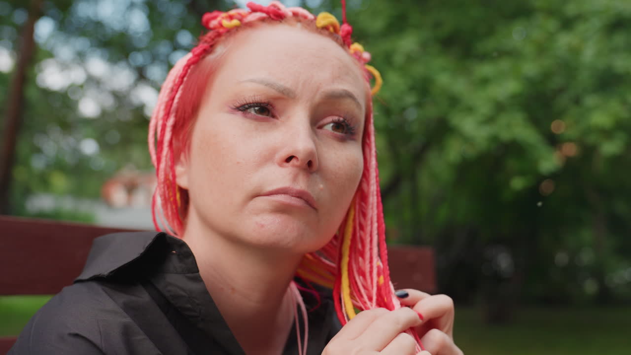 야외에서 우울한 표정으로 생각에 잠긴 여성, 푸른 식물 속에서 사색하는 여성, 야외에서 무성한 나무들 사이에 앉아 있는 생각이 많은 여성, 활기찬 야외 공원 환경에서 땋은 머리를 하고 휴식을 취하는 침울한 여성