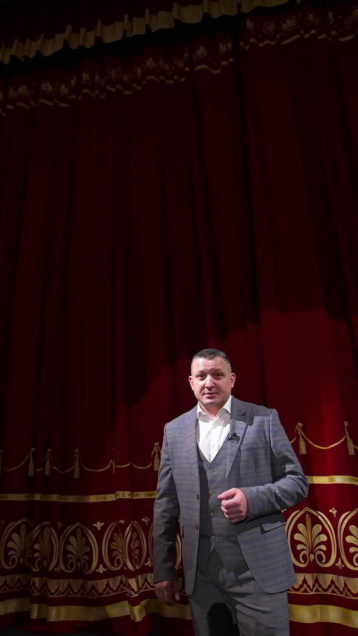 Actor with microphone announces performance before auditorium. Theater curtains background. Vertical video