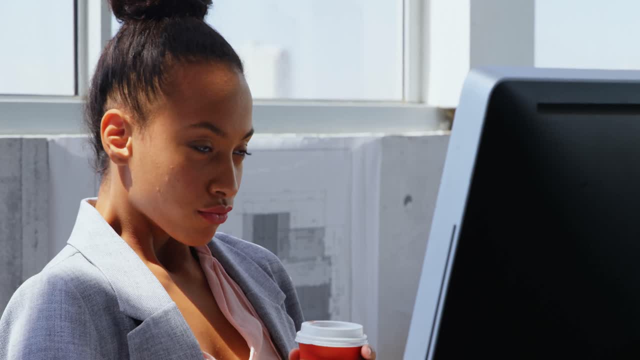 Front view of African American Businesswoman working on computer at desk in a modern office 4k