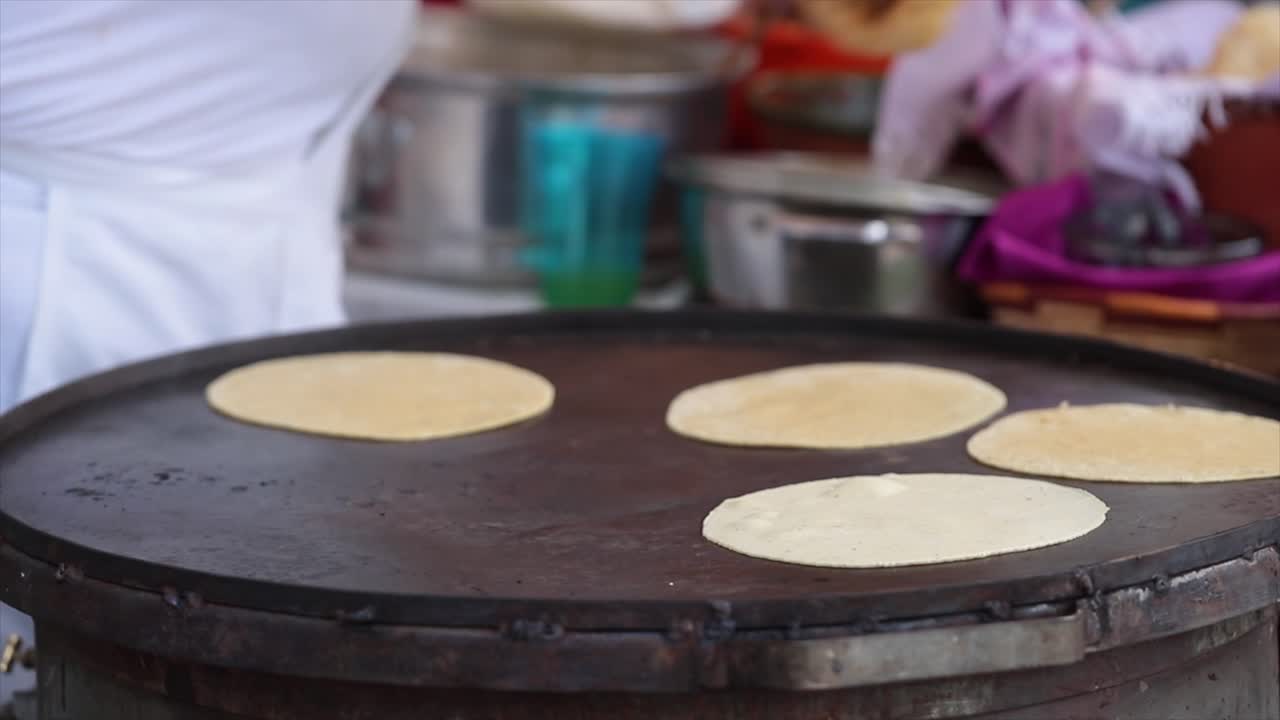 mujer cocinando tortillas hechas a mano en mexico