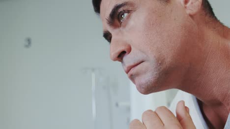 Close-up-of-thoughtful-Caucasian-male-patient-looking-away-in-the-hospital-ward-4k