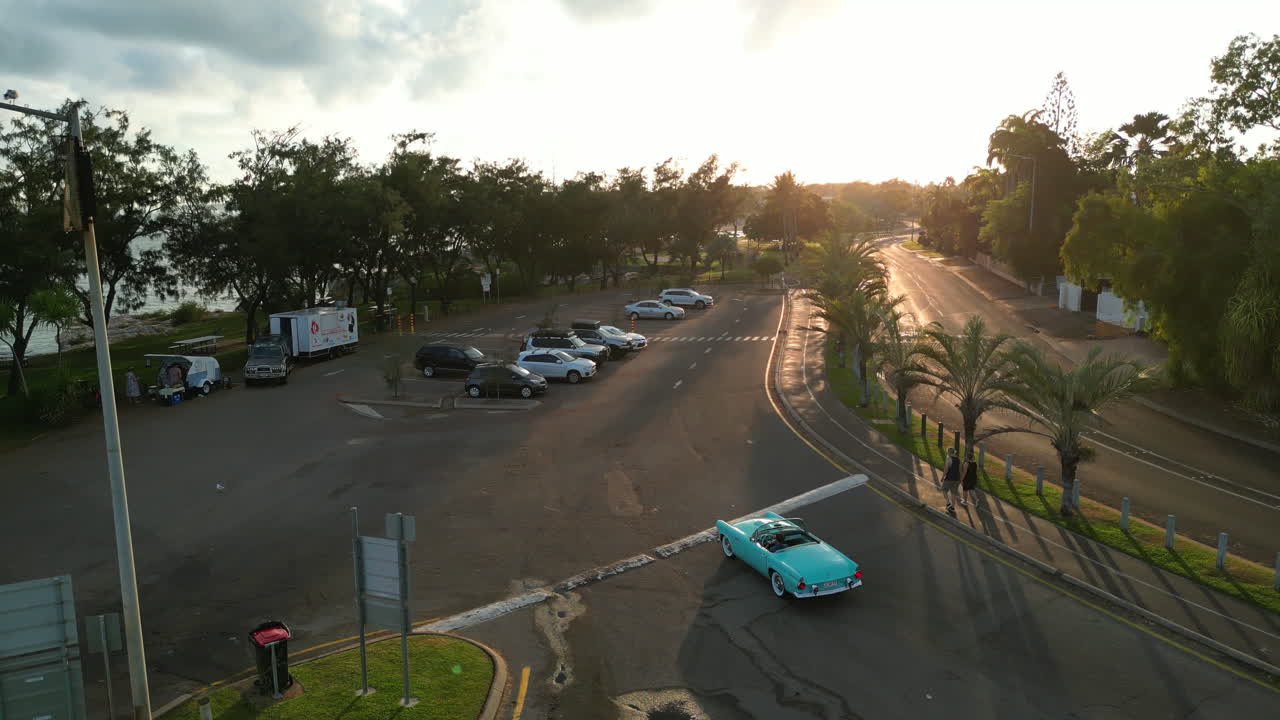 주차장을 빠져나가는 파란 청록색 복고풍 자동차의 드론 공중