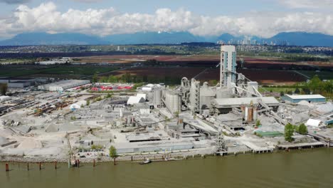 equipo pesado y acopio de materias primas en una planta de fabricación de cemento a lo largo del río fraser en richmond, columbia británica, canadá