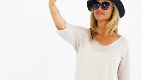 smiling woman taking a selfie against white background