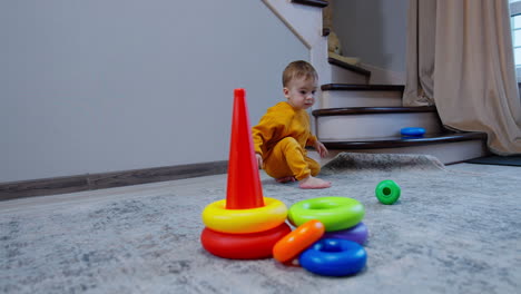 baby playing with stacking rings and cone