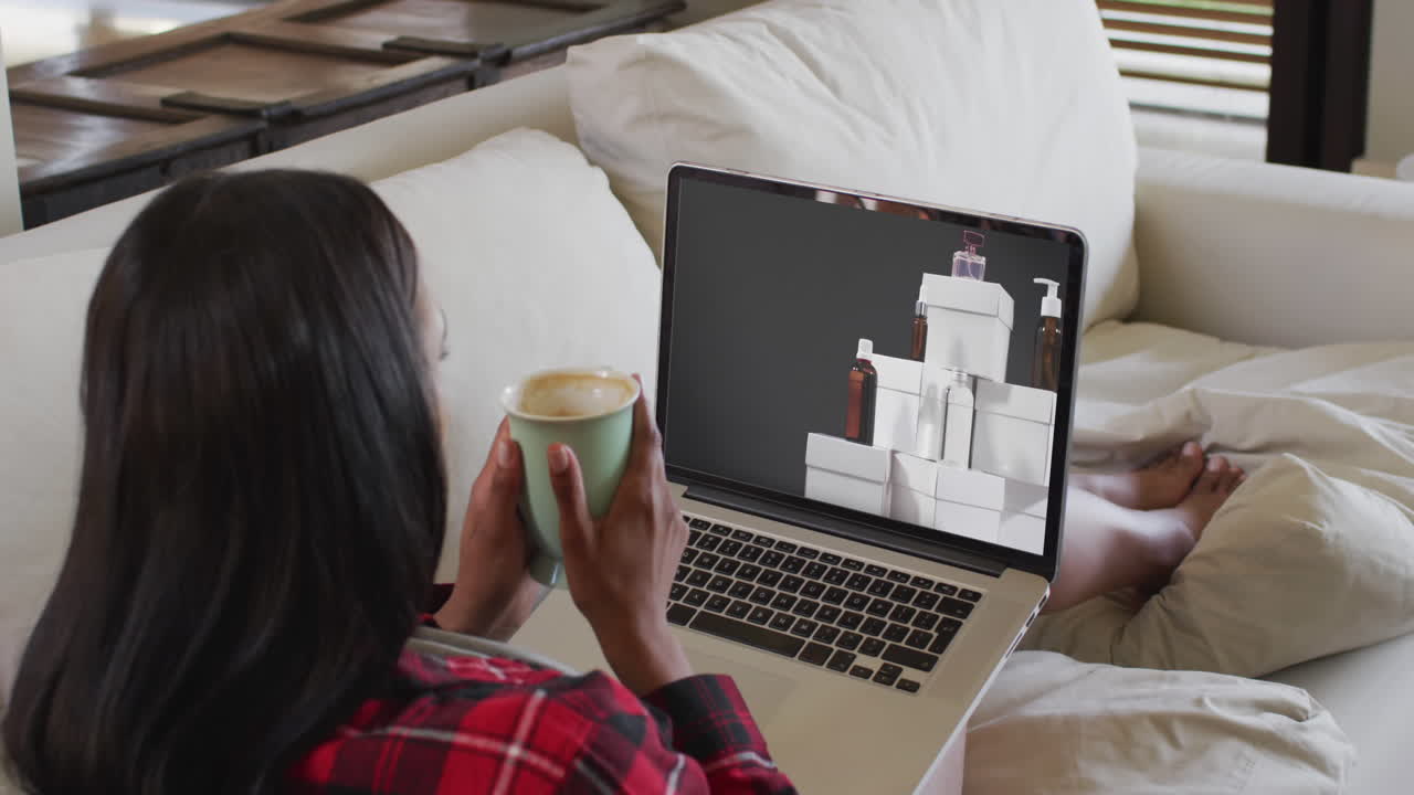 mujer biracial usando una computadora portátil en casa para comprar en línea, cámara lenta