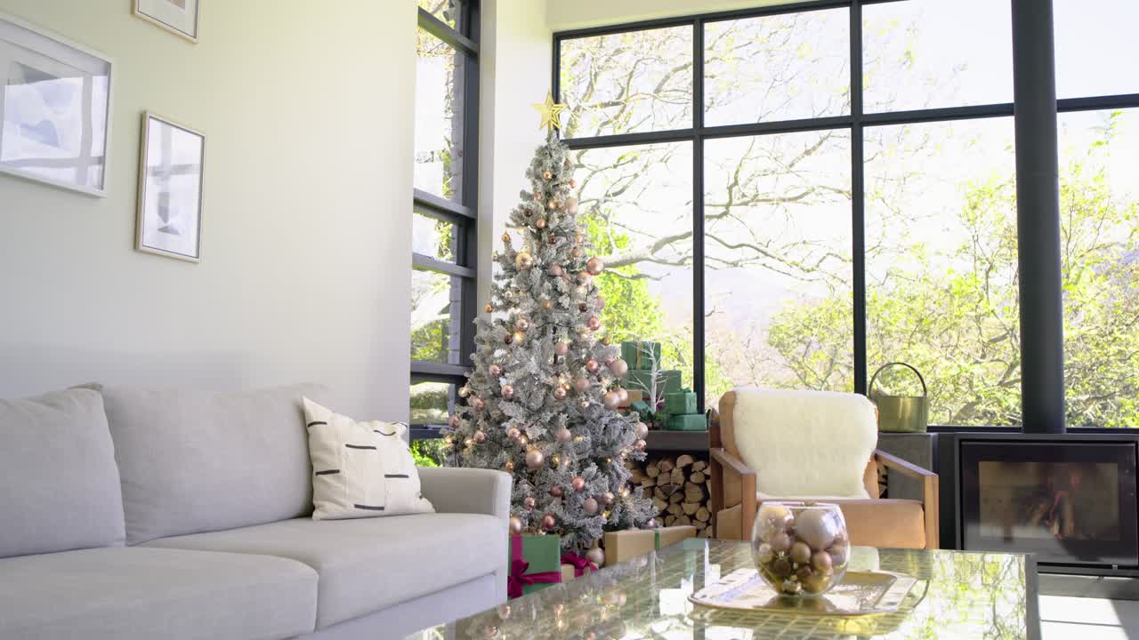 Camera is starting to pan right in living room, revealing Christmas tree, wrapped gifts, fireplace