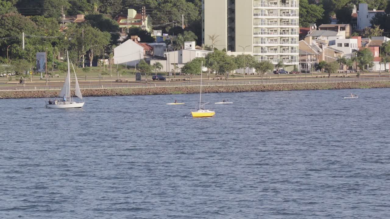 Close-up view of sailboats and kayaks by waterfront buildings, Posadas, Misiones, Argentina.