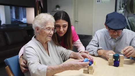 elderly people engaging with a caregiver using wooden blocks