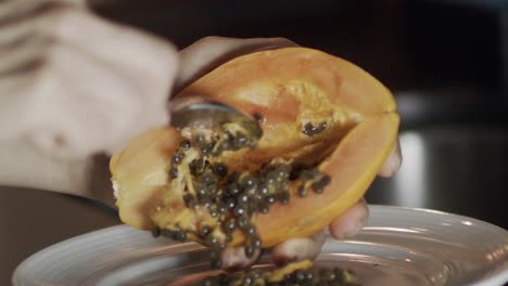 scooping seeds from a ripe papaya