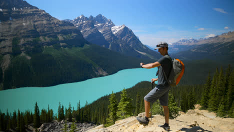 Male-hiker-looking-through-binoculars-on-a-rock-at-countryside-4k