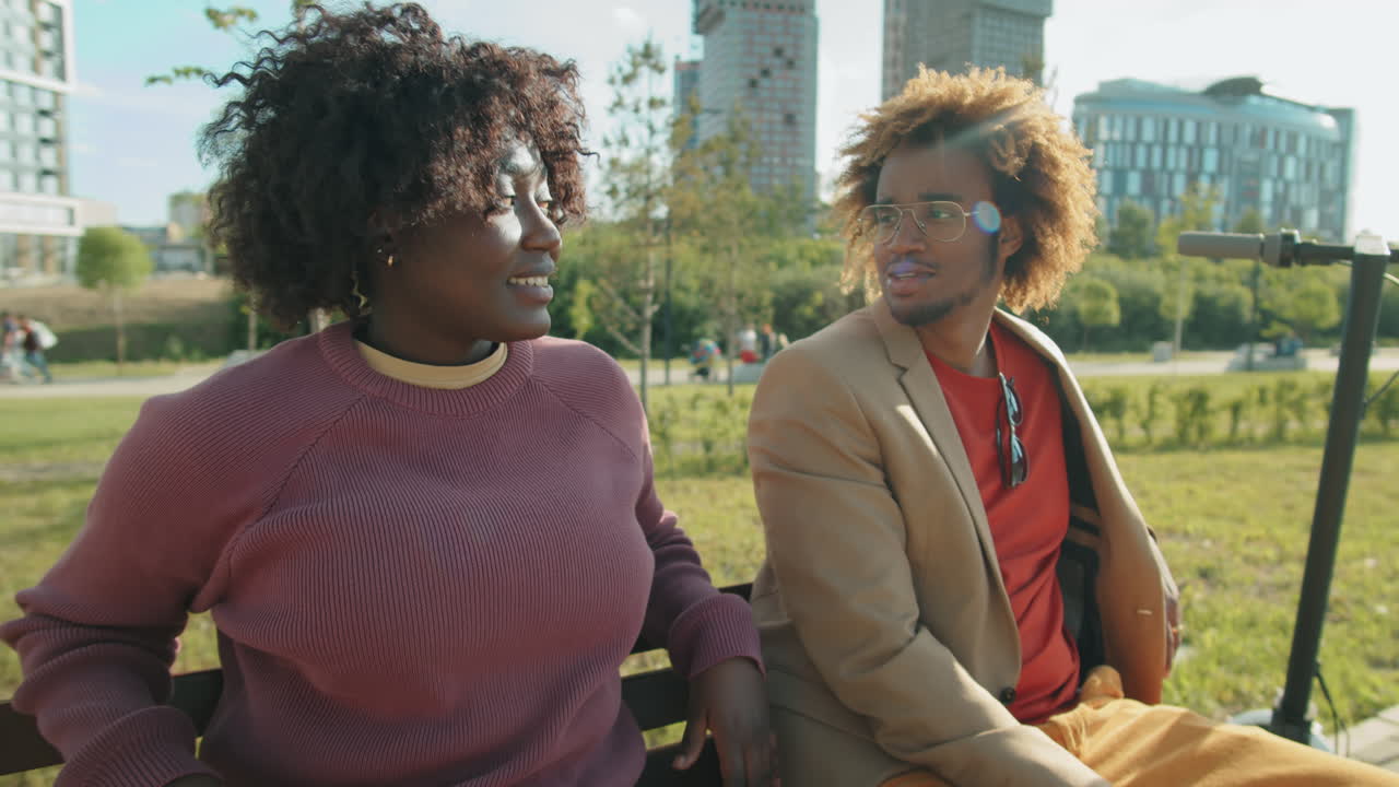amigos afroamericanos charlando en un banco en el parque
