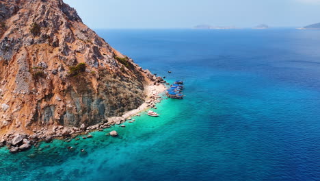 boats stand on the anchor around the huge rock. drone footage over the stunning azure waterscape of the mediterranean sea in turkey